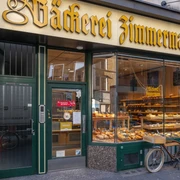 Bakery Zimmermann Außenansicht auf die Bäckerei. Im Schaufenster liegen Backwaren und ein Fahrrad steht davor.Exterior view of the bakery. Baked goods are in the shop window and a bicycle is in front of it.