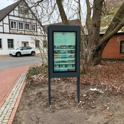 Infoterminal Steyerberg Infoterminal Steyerberg zeigt einen digitalen Bildschirm vor einem Fachwerkgebäude an einer Straßenecke an.