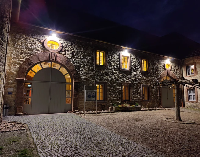 KuStall Ottbergen Abend.jpg Beleuchtete Fassade des Kustalls bei Dunkelheit