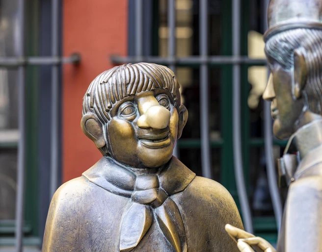 Tünnes and Schäl Monument Die Bronzefigurengruppe zeigt die kölschen Originale "Tünnes und Schäl" im historischen Zentrum von Köln. Beide Figuren sind lebensecht gestaltet.The bronze figure group shows the Cologne originals "Tünnes and Schäl" in the historic center of Cologne. Both figures are designed to be lifelike.