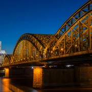 Hohenzollern Bridge Der Kölner Dom, erleuchtet in der Nacht, erhebt sich majestätisch neben der Hohenzollernbrücke, die über den Rhein führt.Cologne Cathedral, illuminated at night, rises majestically next to the Hohenzollern Bridge, which crosses the Rhine.