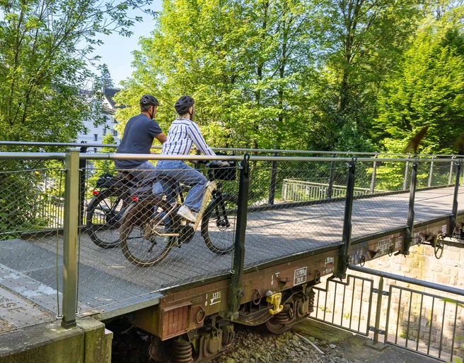 Die Waggongbrücke in Heiligenhaus Zwei Personen mit Helmen überqueren die Waggonbrücke in Heiligenhaus mit ihren Fahrrädern.