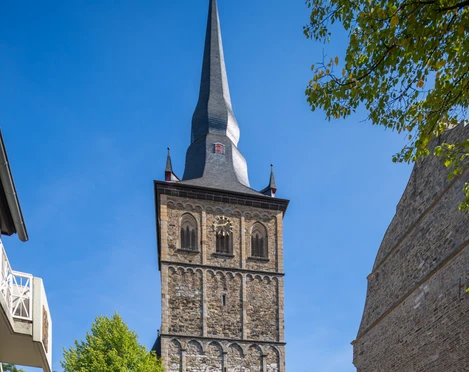 Katholische Pfarrkirche St. Peter und Paul auf dem Marktplatz in Ratingen Historische Kirche St. Peter und Paul in Ratingen, flankiert von grünen Bäumen bei sonnigem Himmel.