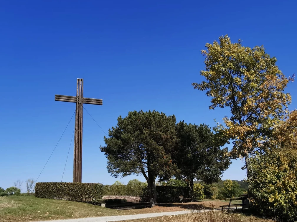 mahnkreuz_stahle_dueker.jpg Großes Holzkreuz auf Bergrücken mit Baumbestand an rechter SeiteLarge wooden cross on a ridge with trees on the right-hand side
