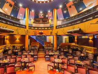 Varietésaal im Krystallpalast Varieté Leipzig - Abendveranstaltungen in Leipzig Blick in den Varietésaal des Krystallpalast Varieté Leipzig mit zahlreichen Stühlen, Tischen und Sitzecken bei heller Beleuchtung, Kultur, Abendveranstaltung