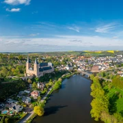 Luftaufnahme Schloss Rochlitz Drohnenaufnahme der Zwickauer Mulde mit dem imposanten Schloss Rochlitz und der Hängebrücke bei Zaßnitz im Frühjahr mit gelben Rapsfeldern in der Ferne, Mulderadweg, Lutherweg Sachsen