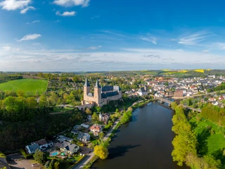Luftaufnahme Schloss Rochlitz Drohnenaufnahme der Zwickauer Mulde mit dem imposanten Schloss Rochlitz und der Hängebrücke bei Zaßnitz im Frühjahr mit gelben Rapsfeldern in der Ferne, Mulderadweg, Lutherweg Sachsen