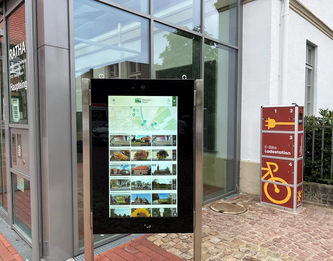 Infoterminal am Rathaus Thedinghausen Infoterminal vor dem Rathaus in Thedinghausen mit digitaler Karte und E-Bike-Ladestation rechts.