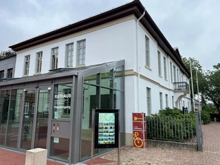 Infoterminal am Rathaus Thedinghausen  Infoterminal am historischen Rathaus Thedinghausen vor modernem Glasvorbau; links, Bäume rechts.