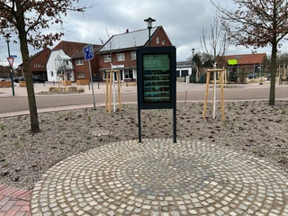 Infoterminal Loccum Infoterminal auf gepflastertem Platz in Loccum, umgeben von jungen Bäumen und Gebäuden im Hintergrund.