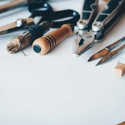Repair Café CASA Auf dem Bild liegen Werkzeuge wie eine Schere, eine Zange und Bleistifte auf einem Tisch.