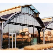 Design Post Köln Die Design Post Köln präsentiert sich als ein modern umgebauter Industriekomplex mit großen Bogenfenstern und einer Glasfassade. Die Architektur verbindet historische Elemente mit zeitgenössischer, klarer Linienführung.The Design Post Köln presents itself as a modern converted industrial complex with large arched windows and a glass façade. The architecture combines historical elements with contemporary, clear lines.