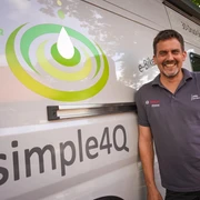 simple4Q.jpg Ein lächelnder Mann lehnt an einem weißen Van mit dem Logo "simple4Q".