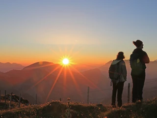 Sunrise of the hiking night Zwei Personen geniessen den Sonnenaufgang über der Diemtigtaler BergketteTwo people enjoy the sunrise over the Diemtigtal mountain rangeDeux personnes admirent le lever du soleil sur la chaîne de montagnes du Diemtigtal