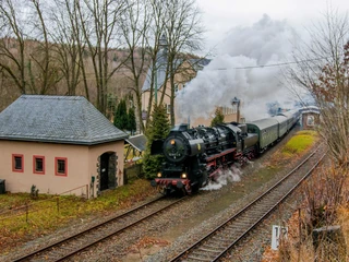 Eisenbahnmuseum Leipzig - Eisenbahnromantik im Herbst Eine historische Dampfbahn passiert einen idyllisch in die Natur eingebetteten Bahnhof im Herbst