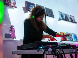 Modularfield DJane mixt elektronische Klänge im gut beleuchteten Raum von Modularfield.DJane mixes electronic sounds in the well-lit room of Modularfield.