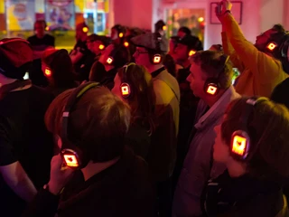 Modularfield  Konzertbesucher tragen beleuchtete Kopfhörer im Modularfield-Shop, um ein immersives Hörerlebnis zu erleben.Concertgoers wear illuminated headphones in the Modularfield store for an immersive listening experience.