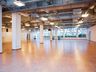 Schlossallee_1.jpg Geräumiger, leerer Veranstaltungssaal mit Holzboden und großen Fenstern; moderne Beleuchtung.</p>Spacious, empty event hall with wooden floor and large windows; modern lighting.</p> <p