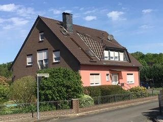FeWo Süchting Ein rotes Backsteinhaus mit modernen Fenstern und gepflegtem Garten in einer ruhigen Wohngegend.