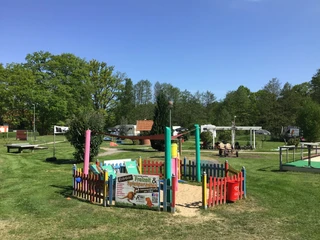 Gasthof und Hotel Rohrbach Ein gepflegter Spielplatz mit buntem Zaun und Infotafeln, umgeben von Wohnmobilen im Grünen.