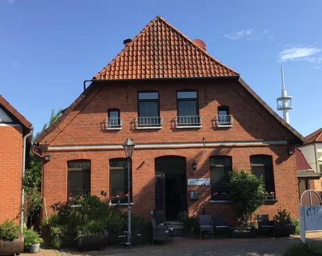 Gästehaus Sorban  Backstein-Gästehaus mit roten Dachziegeln, grünem Pflanzenbewuchs und einem kleinen Eingangsbereich.
