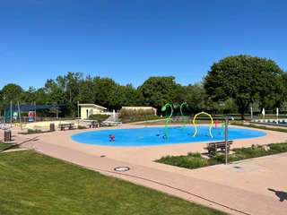 Freibad Achim Moderner Wasserspielplatz im Freibad Achim mit bunten Wasserspritzfiguren und umliegender Grünfläche.