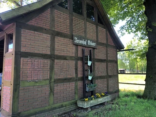 Fachwerkhaus Bruchhausen Das Bild zeigt ein rustikales Fachwerkhaus in Bruchhausen, umgeben von üppigem, grünem Grün.
