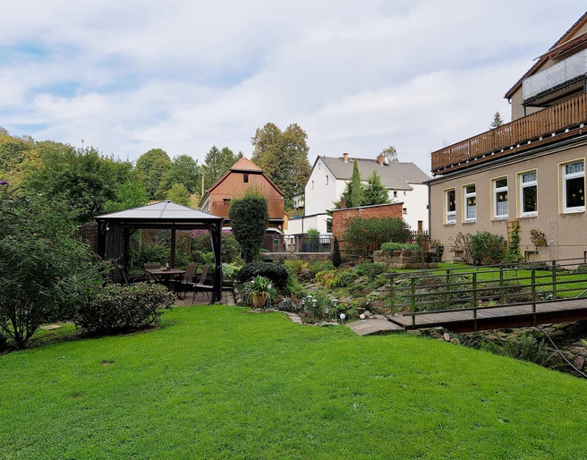 Garten, Holzkohlegrill und überdachte Sitzecke