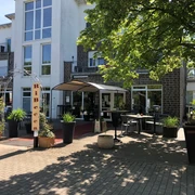 Das RiBecca-Hotel mit moderner Architektur, einem einladenden Eingangsbereich und grüner Bepflanzung.