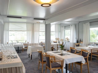 Zur Tant Elegantes Restaurant mit stilvoll gedeckten Tischen und großen Fenstern, die viel Tageslicht hereinlassen.Elegant restaurant with stylishly set tables and large windows that let in plenty of daylight.