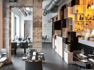 maiBeck Innenaufnahme eines modernen Restaurants mit stilvoll gedeckten Tischen, Holzelementen und Betonoptik.Interior view of a modern restaurant featuring stylishly set tables, wooden elements, and a concrete aesthetic.