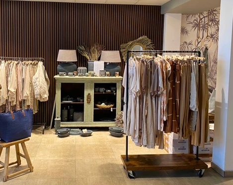 mooi Ecke in einem Geschäft, Kleiderstangen, Vitrine mit Lampen Geschirr und Dekoartikeln