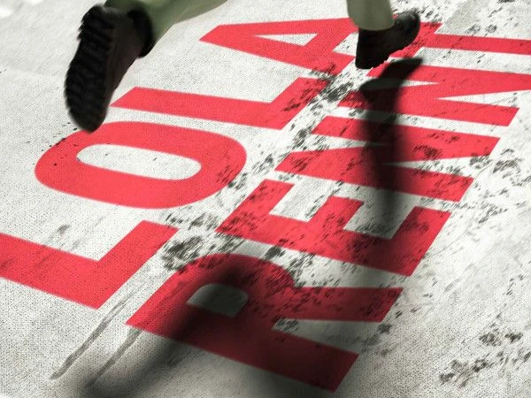 Laufende Beine auf grauem Untergrund mit rotem Schriftzug "LOLA RENNT".