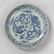 Large dragon shell Schale aus Porzellan mit blauen Drachenmotiven auf hellem Hintergrund.Porcelain bowl with blue dragon motifs on a light-coloured background.