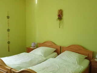 Pension Haus Marbeke Schlafzimmer1.jpg Schlafzimmer mit Holzbetten und hellgrünen Wänden