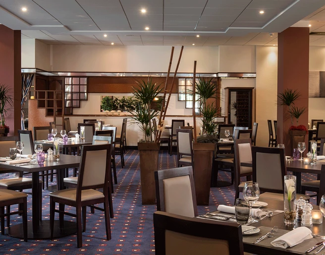 Innenraum im Restaurant Brasserie, Mettmann Der Innenraum eines stilvoll eingerichteten Restaurants mit gedeckten Tischen und warmem Licht.