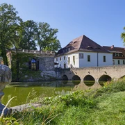 Schlosspark Lampertswalde Die Besucher können sich über das Wasserschloss Lampertswalde mit Wassergraben, Steinbrücke und üppigem Grün an einem klaren, sonnigen Tag freuen.