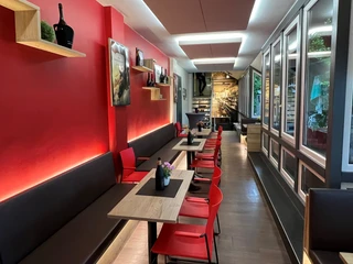 Filmhof Hoya  Modernes Café mit roten Wänden, gemütlicher Sitzbereich und stilvoller Holztischdekoration.