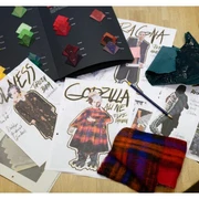 Auf die Spitze getrieben_Ausstellung (c) Couven Museum_Theater Aachen.jpg Designentwürfe und Stoffmuster für Theaterkostüme auf einem Holztisch.