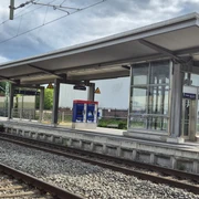 Bahnhof Rastede Moderner Bahnsteig mit Überdachung und gleisnahen Wartehäuschen an einer zweigleisigen Bahnanlage.
