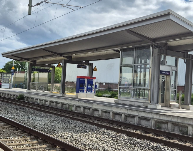 Bahnhof Rastede Moderner Bahnsteig mit Überdachung und gleisnahen Wartehäuschen an einer zweigleisigen Bahnanlage.