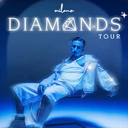 Ein Künstler in futuristischem Outfit unter blauem Licht, mit hellem Text "Diamonds Tour".