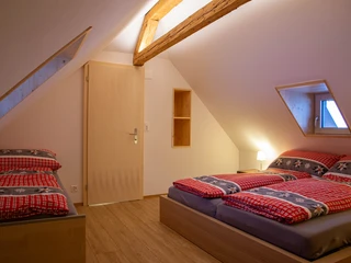 Schlafzimmer mit einem Doppelbett (180x200) und drei Juniorenbetten (90x200)