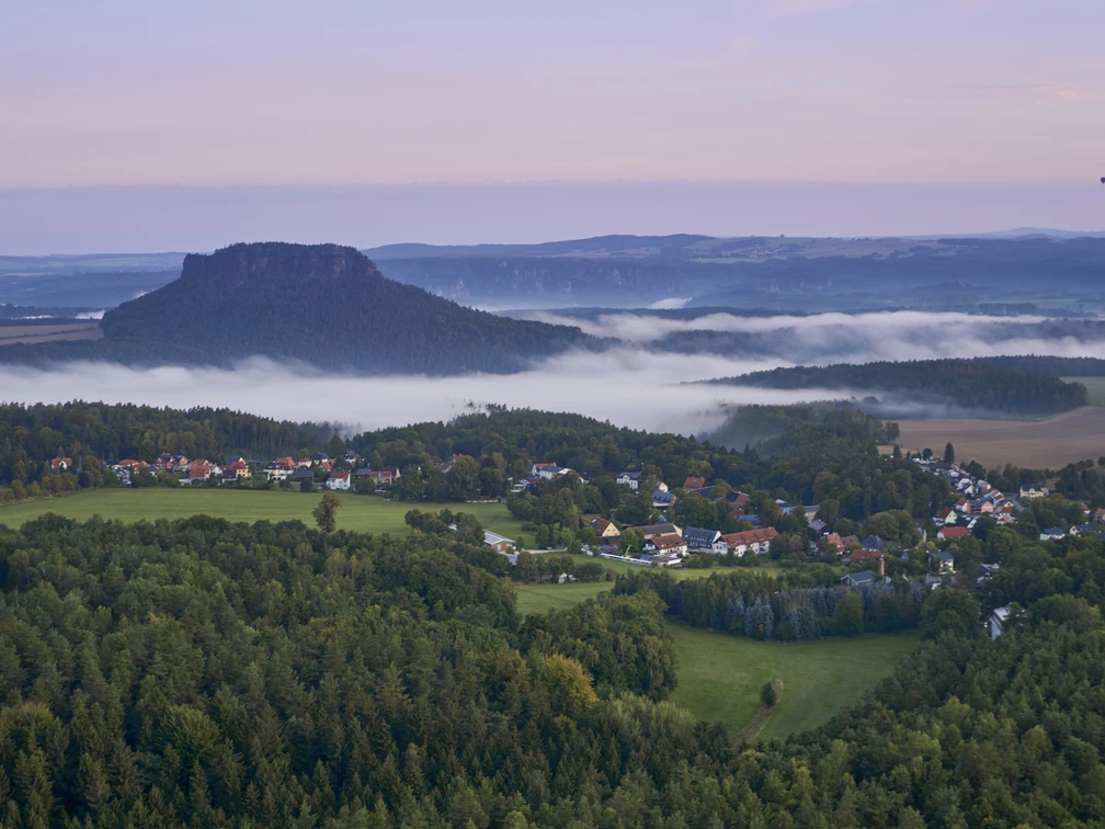 Gohrisch Panoramablick auf Gohrisch im Morgenlicht mit nebelverhüllten Tälern und bewaldeter Landschaft.