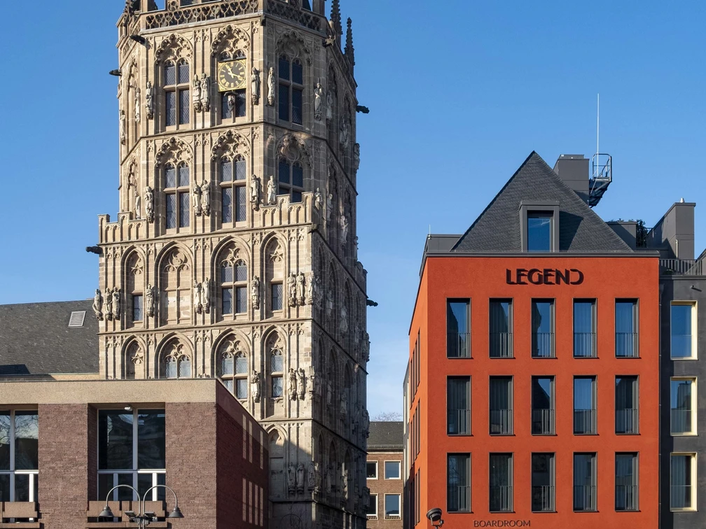 Altermarkt Der historische Rathausturm am Alter Markt in Köln erhebt sich majestätisch neben einem modernen roten Gebäudekomplex.The historic town hall tower on Cologne's Alter Markt rises majestically next to a modern red building complex.