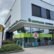 Koopmann Apotheke.jpg Die Koopmann Apotheke ist ein modernes Gebäude mit großer Glasfassade und hellen Schildern.