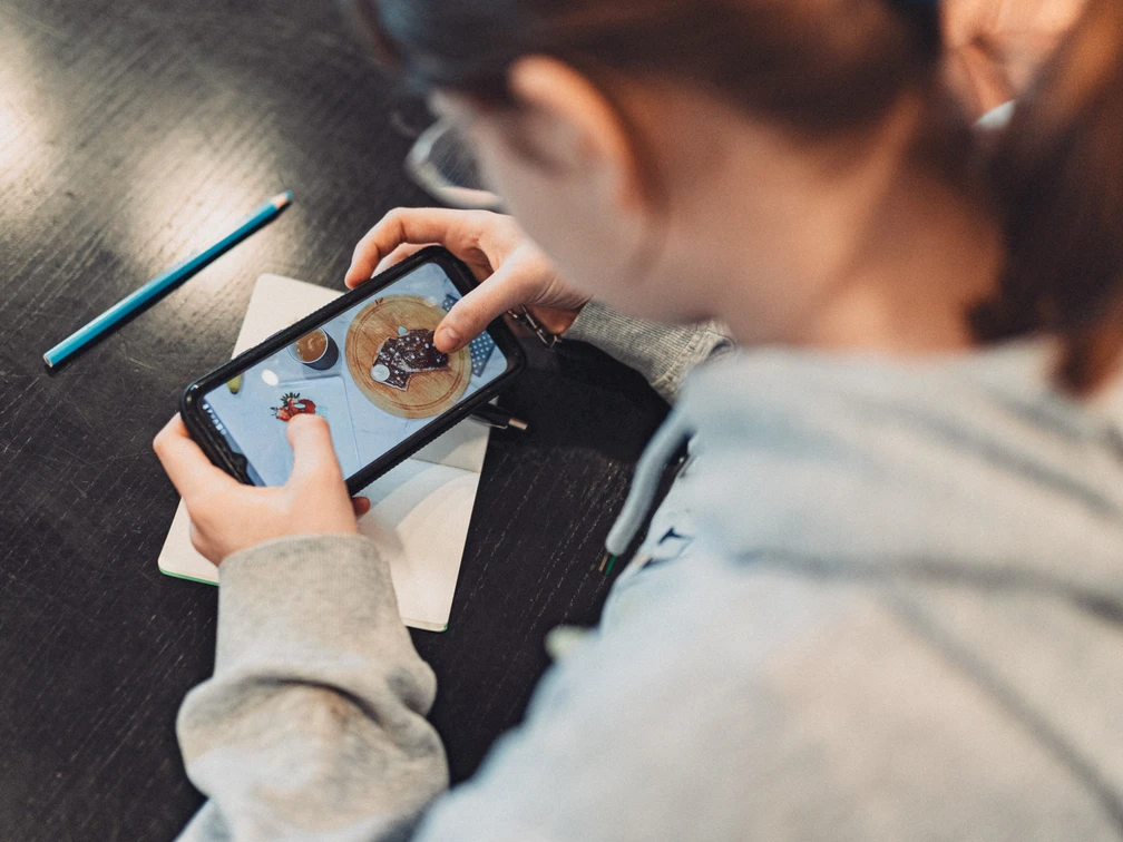 2_2024_03_27_Doku_fuerstenberg_workshop_CWarneke.jpg Mädchen mit Handy fotografiert Plätzchen