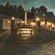 Restaurant Op dä Höh in Hattingen Einladendes Restaurant mit Terrasse und gemütlichen Lichtern in grüner Umgebung am Abend.