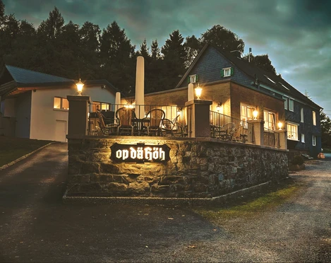 Restaurant Op dä Höh in Hattingen Einladendes Restaurant mit Terrasse und gemütlichen Lichtern in grüner Umgebung am Abend.