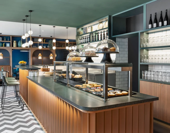 Koko Café & Bar Theke - Cafés in Leipzig Theke mit Gebäckauslage im Koko Café & Bar des Stay Kooook Hotel Leipzig in der Gottschedstraße